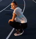 Vrouw zit gehurkt op een basketbalveld met de Hyperboot aan