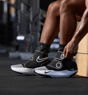 Persoon trekt de Hyperboot by Nike × Hyperice aan in de sportschool