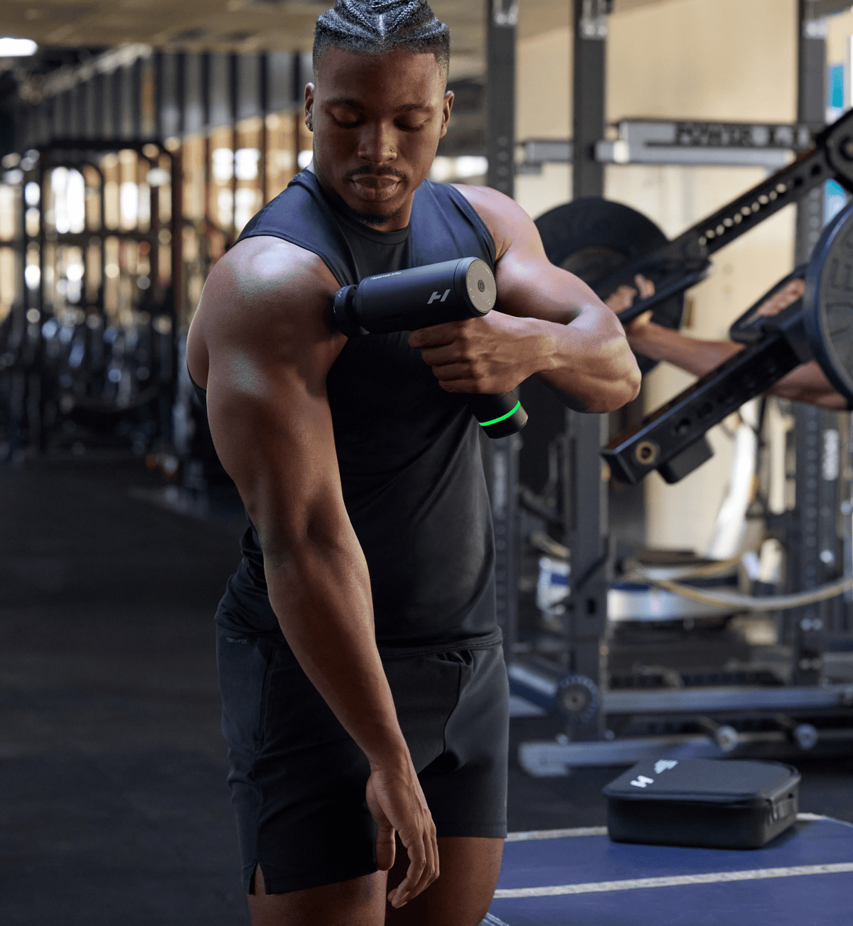 Man in a gym using the Hypervolt 3 Pro massage gun on his shoulder